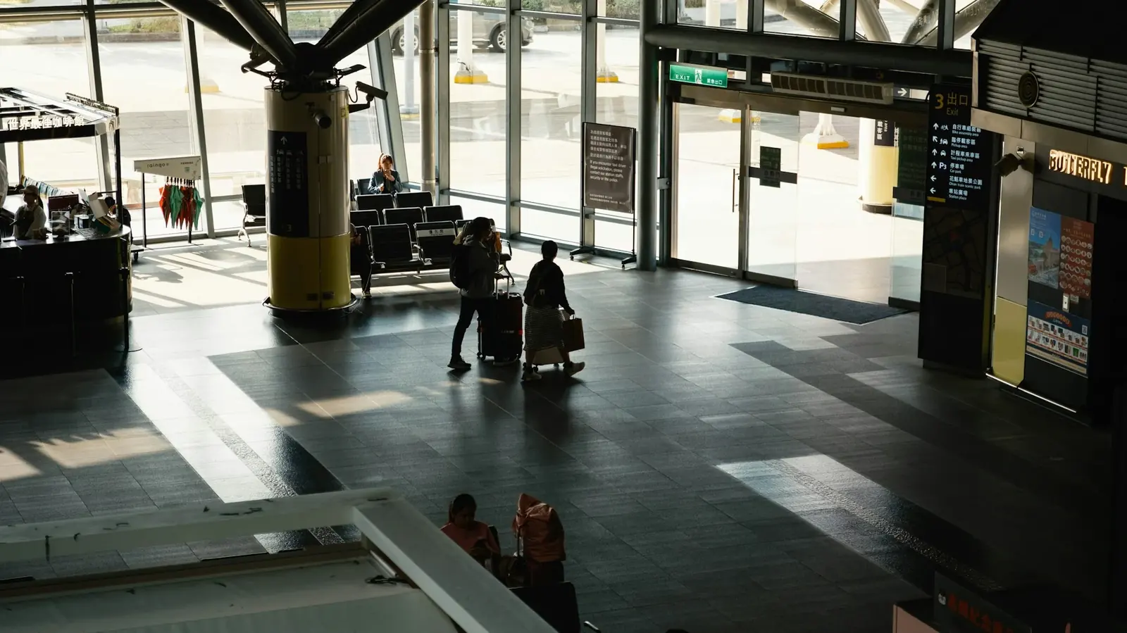 Havalimanı terminalinde valizleriyle yürüyen yolcular