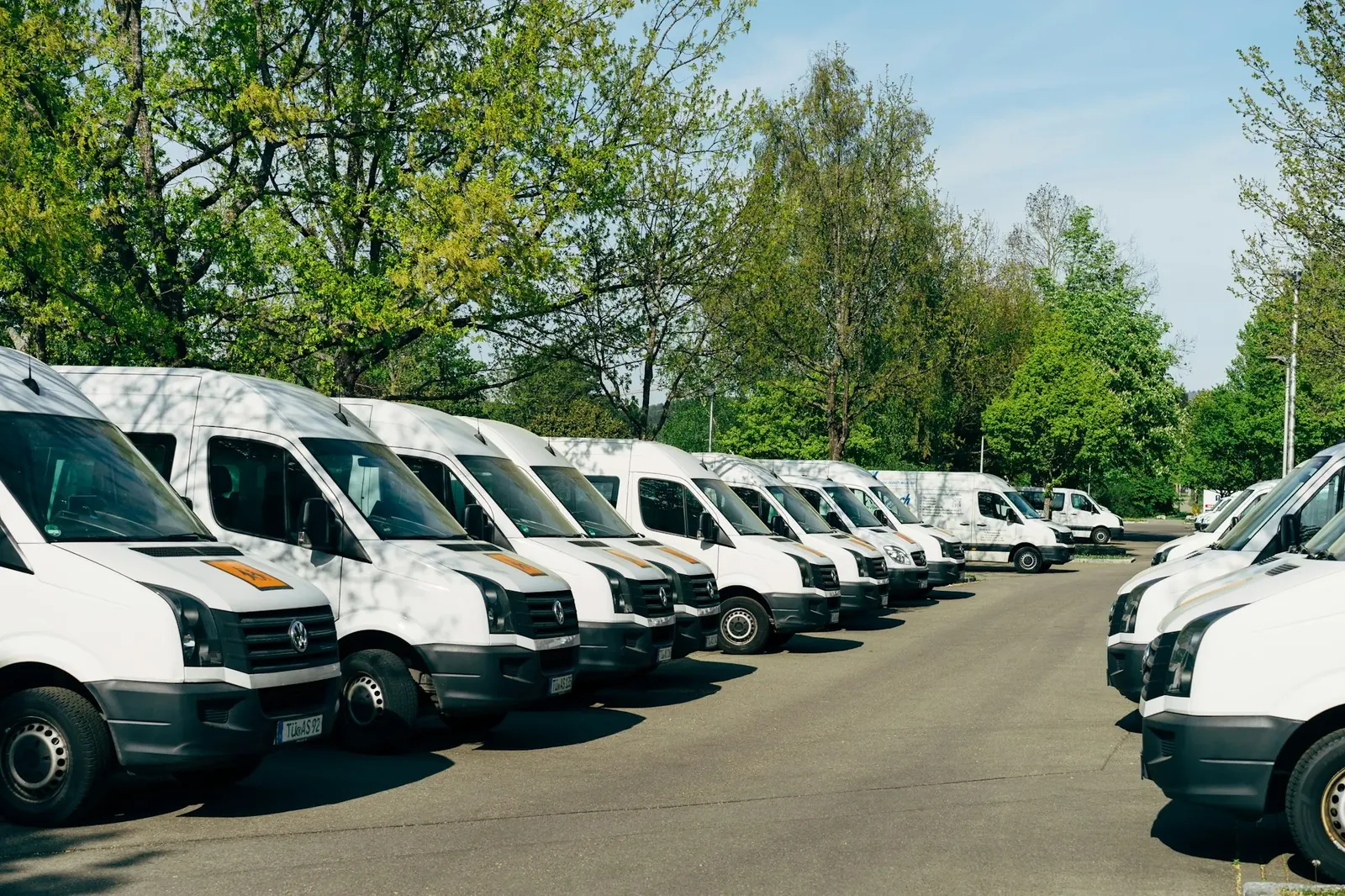 Otoparkta sıralanmış beyaz servis minibüsleri