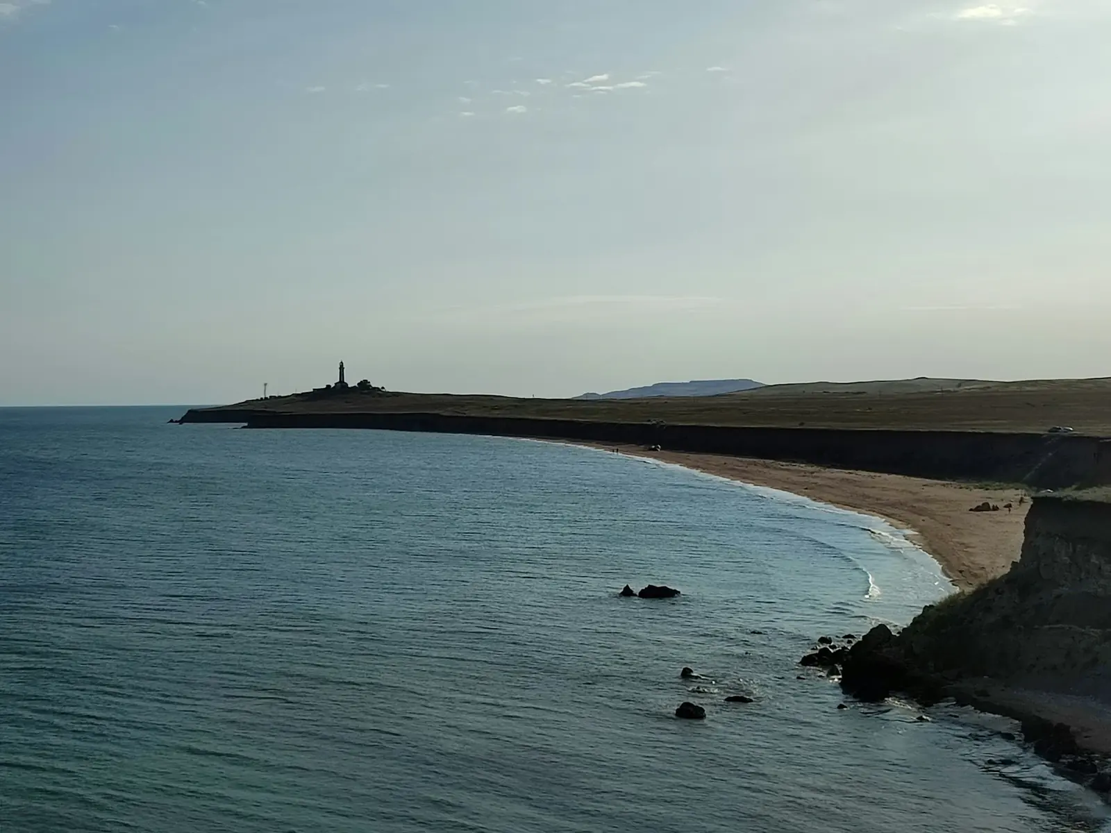 Kıyı şeridinde deniz feneri ve kumsal